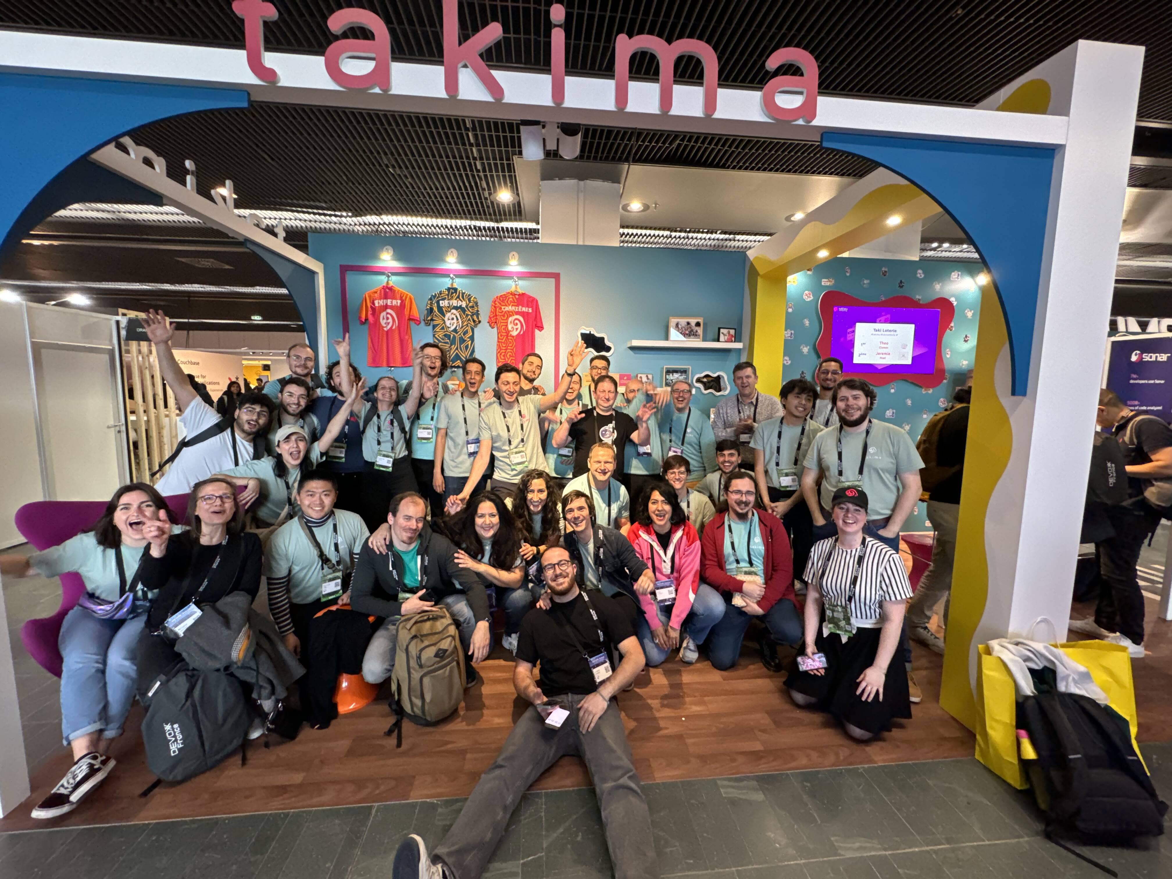 Photo de groupe Takima au devoxx. La majorité des personnes lèvent leurs bras pour poser pour la photo