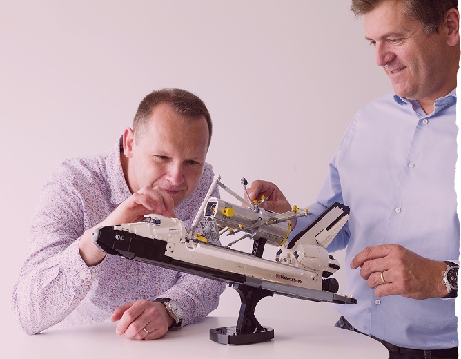Deux hommes qui construisent un avion en Lego