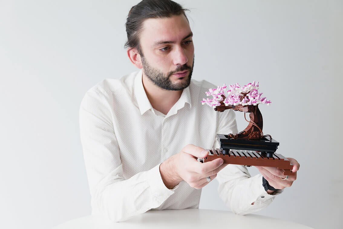 Homme en train de regarder un bonsai en Lego